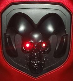 a skull with red eyes and headphones is seen through the door to a vehicle