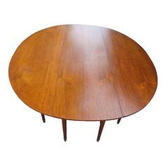 an oval wooden table with two leaves on the top and one leaf at the bottom