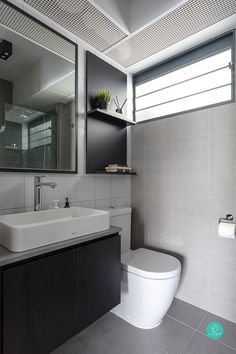 a white toilet sitting next to a sink in a bathroom under a large framed mirror