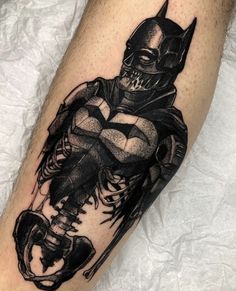 a batman tattoo on the leg of a person with a bat and skull in it