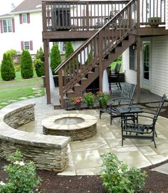 an outdoor patio with steps leading up to the deck and fire pit in the middle