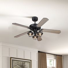 a ceiling fan with three light bulbs in a living room next to a painting on the wall