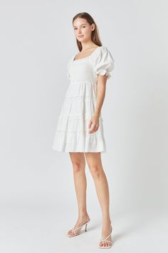 A linen mini dress that is both effortless and eye-catching. The perfect pick for a day out, whether you're running errands or meeting up with friends. The elastic neckline can be worn on or off the shoulder, while the smocked bodice and mini length make this dress both comfortable and flattering. The short puff sleeves and lace trim add a touch of femininity, while the fully lined bodice ensures a smooth fit. Elastic neckline can be worn or off-shoulder Smocked bodice Mini length Short puff sle Chic White Mini Dress With Gathered Neckline, Casual Spring Linen Dress With Smocked Back, White Dress With Smocked Bodice And Straight Neckline, Spring Cotton Smocked Mini Dress, Chic Cotton Smocked Dress For Brunch, Chic Smocked Dress With Elastic Neckline For Day Out, Mini Dress With Elastic Neckline For Brunch, White Smocked Dress With Elastic Neckline For Spring, Chic Smocked Mini Dress For Day Out