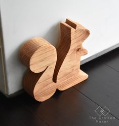 a wooden toy sitting on the floor next to a wall