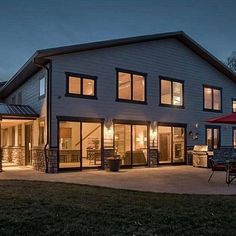 a large white house with lots of windows and lights on it's front porch