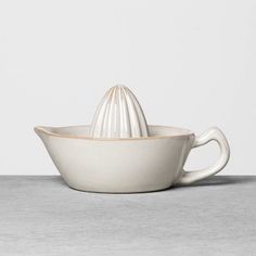 a white ceramic bowl with a cream colored handle