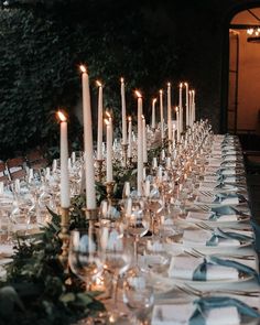 a long table is set with candles and place settings