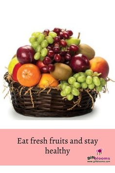 a basket filled with lots of fruit sitting on top of a pink sign that says eat fresh fruits and stay healthy