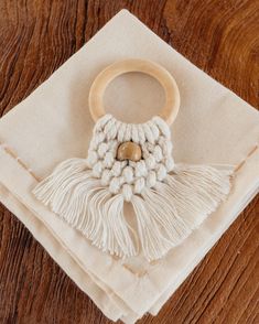 a wooden ring sitting on top of a white napkin with tassels around it