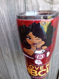 a close up of a cup on a wooden surface with an image of a woman