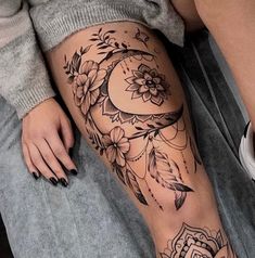 a woman's leg with tattoos and flowers on it