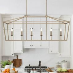 a kitchen filled with lots of white cabinets and counter top next to a stove top oven