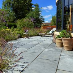 an outdoor patio with potted plants and chairs