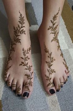 a woman's feet with hennap and leaves on them