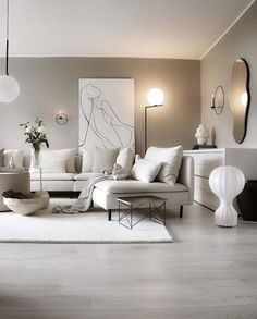 a living room with white furniture and large mirrors