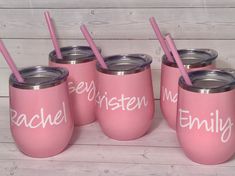 four pink tumblers with matching straws are sitting next to each other on a wooden table