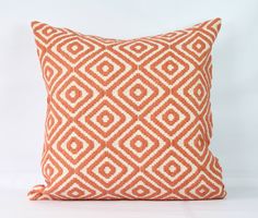 an orange and white pillow on a white background