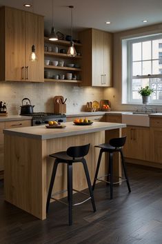 a kitchen with two stools next to an island in the middle of the room