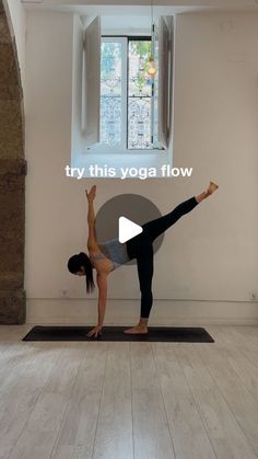 a woman doing yoga in front of a window with the words try this yoga flow