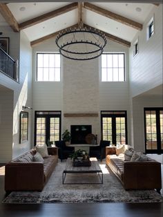 a large living room with high ceilings and wooden beams on the ceiling is filled with furniture