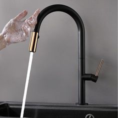 a person washing their hands under a faucet