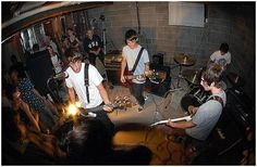 a group of young men playing guitars in a room