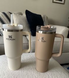 two coffee mugs sitting on top of a table