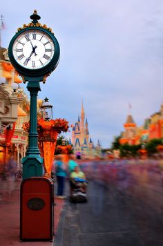 a clock on a pole in the middle of a street