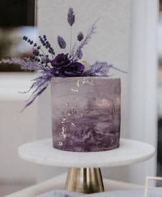 a cake with purple frosting and flowers on top