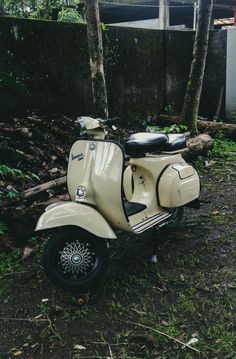 a scooter is parked in the grass near some trees