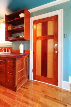 a kitchen with wooden floors and blue walls