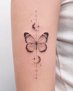 a woman's arm with a butterfly and half moon tattoo on the left side