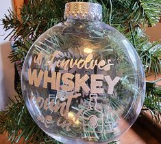 a glass ornament hanging from a christmas tree with the words, made in whiskey