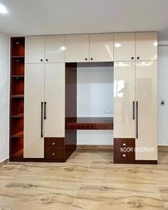 an empty room with white cabinets and wood flooring