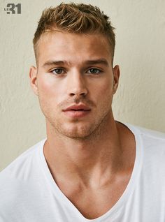 a close up of a person wearing a white t - shirt and looking at the camera