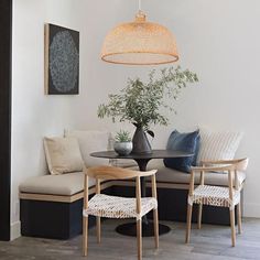 a living room filled with furniture and a lamp hanging from the ceiling over a table