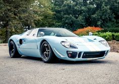 a blue and white sports car parked in a parking lot