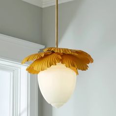 a light hanging from a ceiling with a flower on the bottom and yellow petals attached to it