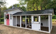 a white chicken coop with pink doors and windows