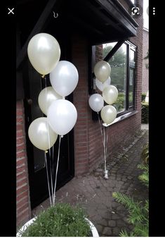 some white balloons are in front of a house