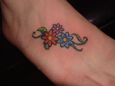 a small flower tattoo on the foot