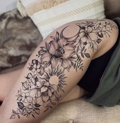 a woman's thigh with flowers and leaves on her leg, in black and white