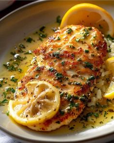 a white plate topped with chicken and lemon slices