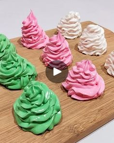 there are many different colored cupcakes on the cutting board