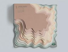 a wall mounted calendar with an abstract design on the front and back of it, in pastel tones