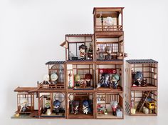 a group of wooden dolls houses with figurines in them