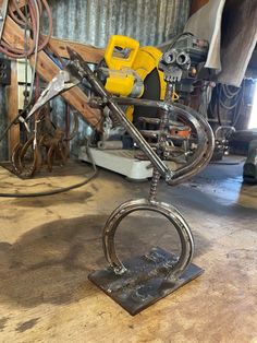 a metal sculpture sitting on top of a wooden table next to a pile of tools