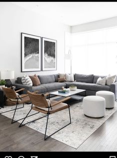 a living room filled with furniture next to a large window and potted plant on top of a hard wood floor