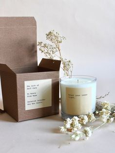 a candle sitting next to a box and some flowers