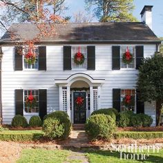 a large white house with wreaths on the windows